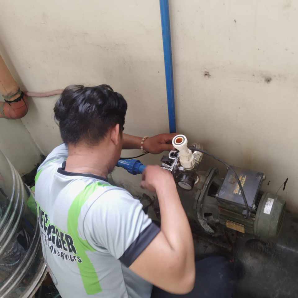Plumber repairing a water pump and pipe connection